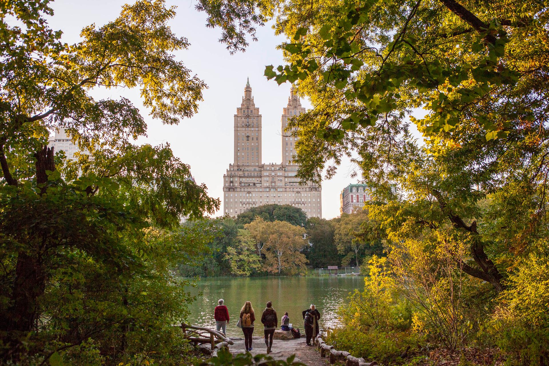 People enjoying the lake viewing area of Central Park, in Manhattan
