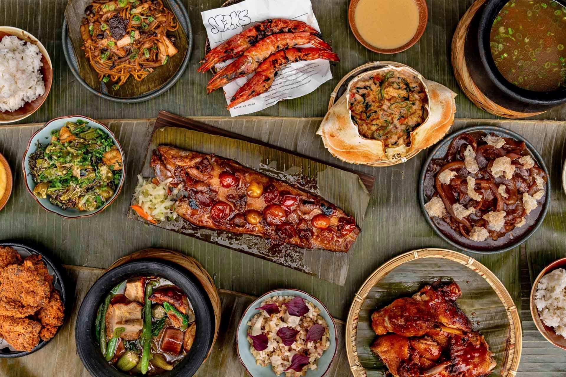 A vibrant and diverse array of Filipino dishes served on a banana leaf. Includes grilled pork belly, shrimp, vegetable stir-fry, and other traditional foods, creating a colorful and appetizing display.