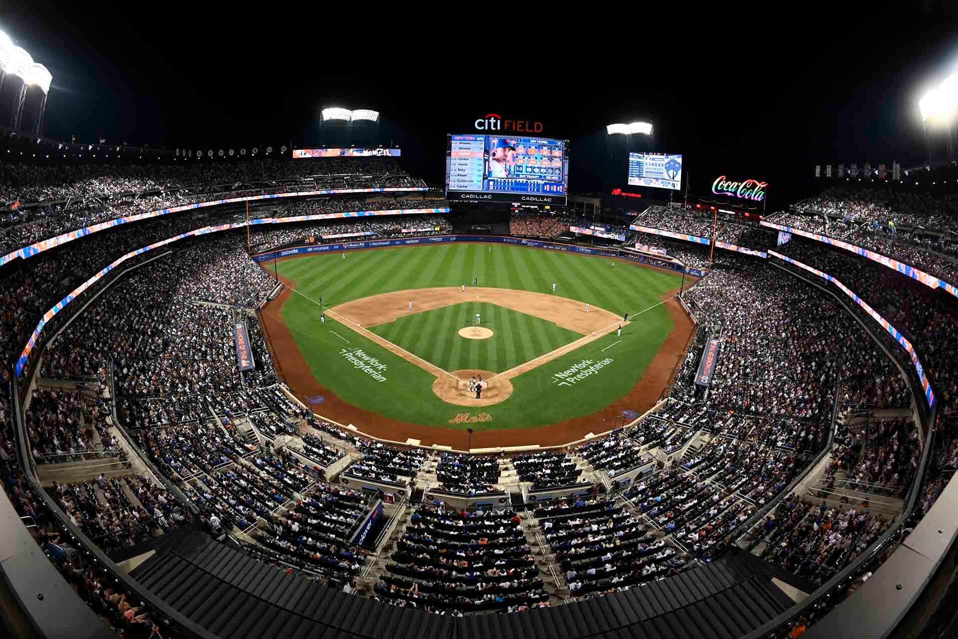 Aerial view of CitiField at night, with fans filling the stands and players on the brightly lit field during a game.