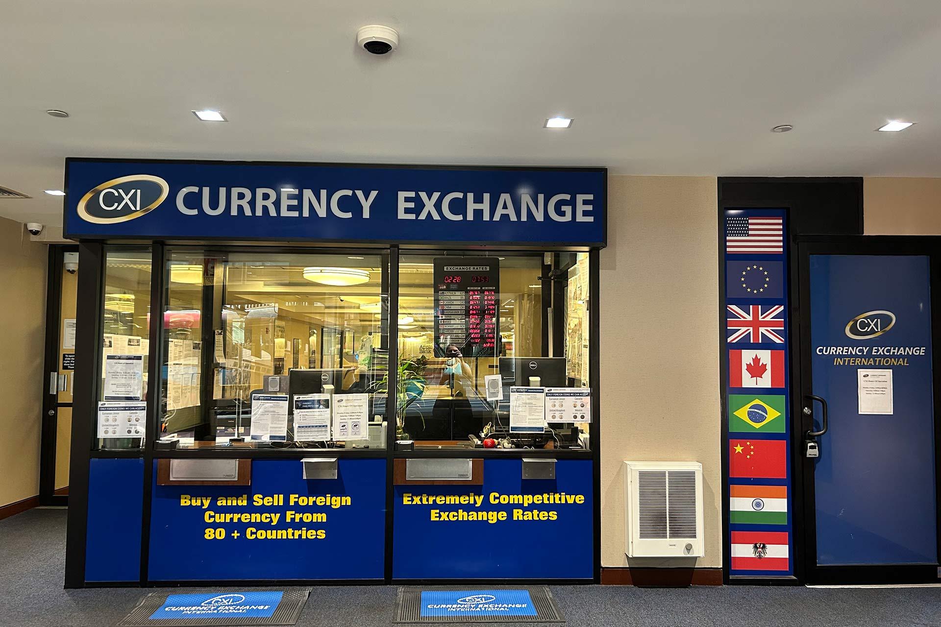 A currency exchange storefront with signs reading "Buy and Sell Foreign Currency from 80+ Countries" and "Extremely Competitive Exchange Rates." Flags of several countries are displayed beside the entrance.